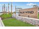 Palm Wind community entrance sign with stone base, wooden background, and palm tree landscaping at 13548 Tropical Breeze Way, Hudson, FL 34669