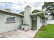 This backyard features a brick chimney and grill, green siding and an entry door at 1461 S Hillcrest Ave, Clearwater, FL 33756