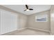 This bedroom features a ceiling fan, neutral walls, carpet, and a window for natural light at 1461 S Hillcrest Ave, Clearwater, FL 33756