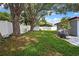 Spacious fenced backyard with mature trees and lush green lawn, perfect for outdoor entertaining at 1809 Chinaberry Dr, Oldsmar, FL 34677