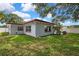 Exterior view of the house with a well-maintained lawn and a white vinyl fence at 1809 Chinaberry Dr, Oldsmar, FL 34677
