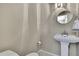 Cozy half bathroom features a pedestal sink, round mirror and neutral decor at 1809 Chinaberry Dr, Oldsmar, FL 34677