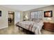 Cozy bedroom with wood-look tile floors leading into the bright adjoining dining room at 1809 Chinaberry Dr, Oldsmar, FL 34677