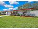 Single story house with red trim and planted garden in front of the house and attached garage at 1809 Chinaberry Dr, Oldsmar, FL 34677