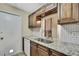 Traditional kitchen features granite counters, stainless steel sink, wood cabinets and tiled backsplash at 1809 Chinaberry Dr, Oldsmar, FL 34677