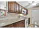 Traditional kitchen features granite counters, white appliances, wood cabinets and tiled backsplash at 1809 Chinaberry Dr, Oldsmar, FL 34677