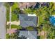 Aerial view of property featuring outlined lot with green lawn and dark grey roofing at 200 Lamara Ne Way, St Petersburg, FL 33704