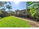 Backyard of home features lush grass and brick paver patio, complemented by surrounding trees and plants at 200 Lamara Ne Way, St Petersburg, FL 33704