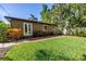 Well-maintained backyard featuring lush grass, a brick patio, and mature landscaping for enhanced privacy at 200 Lamara Ne Way, St Petersburg, FL 33704