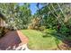 Expansive backyard with brick paver patio and lush tropical landscaping offers a private outdoor retreat at 200 Lamara Ne Way, St Petersburg, FL 33704
