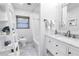 Bright bathroom featuring marble floors, a shower with a tub, and a white vanity with elegant fixtures at 200 Lamara Ne Way, St Petersburg, FL 33704