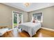 Bright bedroom with hardwood floors, a white duvet, and French door access to a patio at 200 Lamara Ne Way, St Petersburg, FL 33704