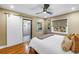 Cozy bedroom with hardwood floors, a ceiling fan, and sliding barn door to ensuite bathroom at 200 Lamara Ne Way, St Petersburg, FL 33704