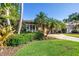 Landscaped front yard featuring tropical foliage and a patterned driveway leading up to a charming single-story home at 200 Lamara Ne Way, St Petersburg, FL 33704