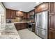 Modern kitchen with dark wood cabinets, stainless steel appliances, and a tile backsplash at 200 Lamara Ne Way, St Petersburg, FL 33704