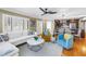 Open-concept living area with hardwood floors, plantation shutters, and modern furnishings flowing into the dining area at 200 Lamara Ne Way, St Petersburg, FL 33704