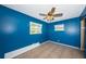 Bedroom with blue walls, tile flooring, two windows, and a ceiling fan at 2003 Whispering Pines St, Largo, FL 33774