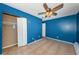 Bedroom with blue walls, tile flooring, closet, and ceiling fan at 2003 Whispering Pines St, Largo, FL 33774
