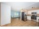 Modern kitchen open to the living area with stainless steel appliances and tile floors at 2003 Whispering Pines St, Largo, FL 33774