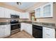 Traditional kitchen featuring white cabinets, granite countertops and stainless steel appliances at 2003 Whispering Pines St, Largo, FL 33774