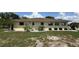 The back exterior features an AC unit, mature landscaping, and a well-manicured lawn at 205 Strong Bow Ct, Sun City Center, FL 33573