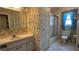 The bathroom features a single sink, updated vanity, and a shower-tub combo with floral wallpaper and tile floor at 205 Strong Bow Ct, Sun City Center, FL 33573