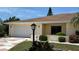Charming home featuring a landscaped yard, patterned driveway, and attached two-car garage at 205 Strong Bow Ct, Sun City Center, FL 33573