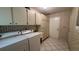 The laundry room showcases a washer, dryer, and storage cabinets on tile flooring with wallpaper at 205 Strong Bow Ct, Sun City Center, FL 33573