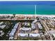 A sunny aerial view shows a community with a boat dock near a canal that leads to white sand beaches at 208 Haven Beach Ct, Indian Rocks Beach, FL 33785