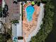 Aerial view of a community pool, showcasing lounge chairs, umbrellas, and landscaping at 208 Haven Beach Ct, Indian Rocks Beach, FL 33785