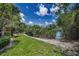 Lush backyard with a charming walking path leading to tranquil waterway, perfect for nature lovers at 208 Haven Beach Ct, Indian Rocks Beach, FL 33785