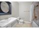 Bathroom with a pedestal sink, modern toilet, framed mirror, and a shower-tub combo with tile surround at 208 Haven Beach Ct, Indian Rocks Beach, FL 33785