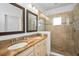 Bathroom with double vanity, framed mirrors, granite counters, and a glass-enclosed shower with tile surround at 208 Haven Beach Ct, Indian Rocks Beach, FL 33785