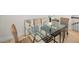 Modern dining area featuring a glass table, wicker chairs, and contemporary wall art at 208 Haven Beach Ct, Indian Rocks Beach, FL 33785