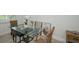 Bright dining area featuring a glass table, wicker chairs, and modern artwork at 208 Haven Beach Ct, Indian Rocks Beach, FL 33785