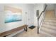 Bright foyer with tile flooring, a bench, staircase, and an eye-catching piece of wall art at 208 Haven Beach Ct, Indian Rocks Beach, FL 33785
