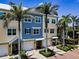 A charming exterior view showcases the coastal architecture and lush tropical landscaping of this Indian Rocks Beach townhome at 208 Haven Beach Ct, Indian Rocks Beach, FL 33785