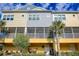 Charming townhouse exterior featuring colorful siding, screened-in patios, and lush landscaping, offering a relaxing outdoor space at 208 Haven Beach Ct, Indian Rocks Beach, FL 33785