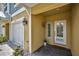 Inviting covered front porch with stylish lighting, a white garage door, and a brick pathway at 208 Haven Beach Ct, Indian Rocks Beach, FL 33785
