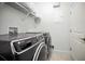 Laundry room featuring a side-by-side washer and dryer with overhead shelving and a door to a utility closet at 208 Haven Beach Ct, Indian Rocks Beach, FL 33785
