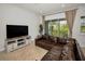 Comfortable living room with a large leather sofa, modern entertainment center, and a sliding glass door at 208 Haven Beach Ct, Indian Rocks Beach, FL 33785