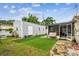 View of the backyard with storage building, artificial turf, and partially-covered patio at 2818 Lorraine St, Tampa, FL 33614