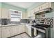 Well-lit kitchen with stainless steel appliances and black and white backsplash at 2818 Lorraine St, Tampa, FL 33614