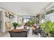 This is a sunroom with tile flooring, plants, outdoor furniture and a television at 2818 Lorraine St, Tampa, FL 33614