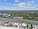 Beautiful aerial view of a beachfront property with a river nearby, palm trees, and gorgeous blue skies with fluffy clouds at 30 Gulf Blvd, Indian Rocks Beach, FL 33785