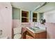 Pink-tiled bathroom featuring a damaged vanity and outdated fixtures at 30 Gulf Blvd, Indian Rocks Beach, FL 33785