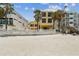 Beachfront home featuring three stories and lots of windows, nestled among palm trees at 30 Gulf Blvd, Indian Rocks Beach, FL 33785