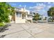 Spacious front parking area and home exterior with landscaped yard and mature palm trees at 30 Gulf Blvd, Indian Rocks Beach, FL 33785