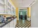 Charming kitchen with yellow and white cabinets, black and yellow checkerboard floor at 30 Gulf Blvd, Indian Rocks Beach, FL 33785