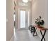 Bright and airy entryway with white tile flooring, transom window, and stylish console table at 3060 Mountain Spruce Ter, Wesley Chapel, FL 33543